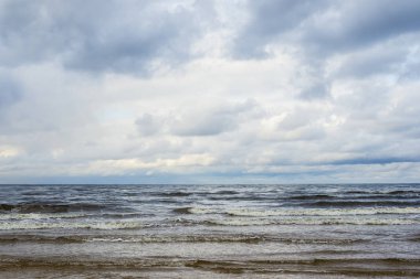 Bulutlu bir mavi fırtınalı havada, Letonya Baltık denizin dalgaları