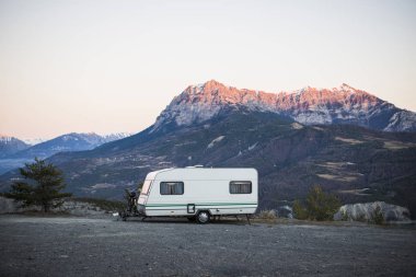 Fransız Alps Gölü Lac de Serre-Poncon yakınındaki bir görünüm ile bir dağın tepesinde bir bisiklet ile karavan park