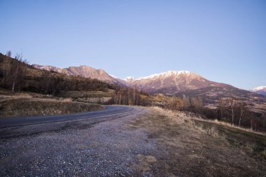 Göl Lac de serre-poncon Fransız Alpleri'nde açık bir günde yakınındaki dağlarda bir asfalt yol