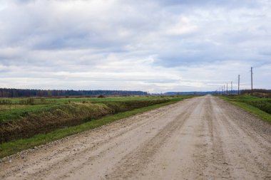 Bulutlu bir günde, Letonya ile yeşil alanlar ülke yolun bir görünüm