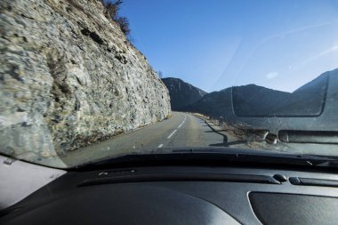 Bir araba bir görünümden Gölü Lac de serre-poncon Fransız Alpleri'nde açık bir günde yakınındaki dağlarda bir asfalt yolda