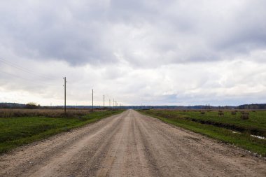 Bulutlu bir günde, Letonya ile yeşil alanlar ülke yolun bir görünüm