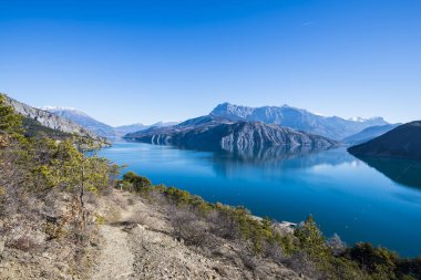 Göl Lac de serre-poncon Fransız Alpleri'nde açık bir günde yakınındaki dağların bir görünüm