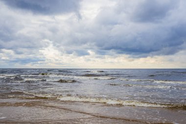 Bulutlu bir mavi fırtınalı havada, Letonya Baltık denizin dalgaları
