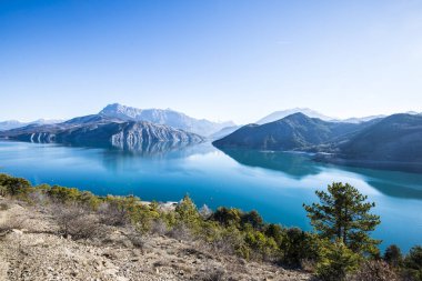 Göl Lac de serre-poncon Fransız Alpleri'nde açık bir günde yakınındaki dağların bir görünüm