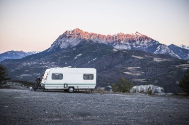 Fransız Alps Gölü Lac de Serre-Poncon yakınındaki bir görünüm ile bir dağın tepesinde bir bisiklet ile karavan park