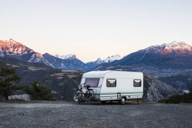 Fransız Alps Gölü Lac de Serre-Poncon yakınındaki bir görünüm ile bir dağın tepesinde bir bisiklet ile karavan park