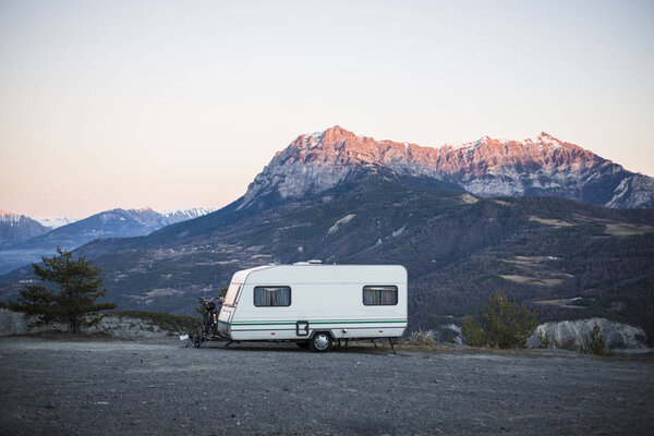 Караван с велосипедом, припаркованным на вершине горы с видом на французские Альпы возле озера Лак-де-Серр-Понкон
