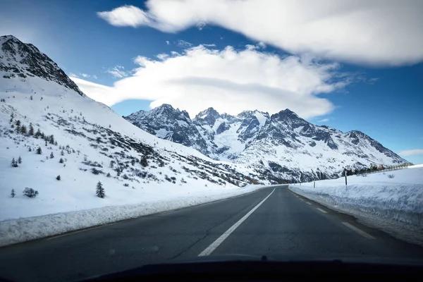 A view from the car on an asphalt road in French Alps mountains near Parc Ecrins