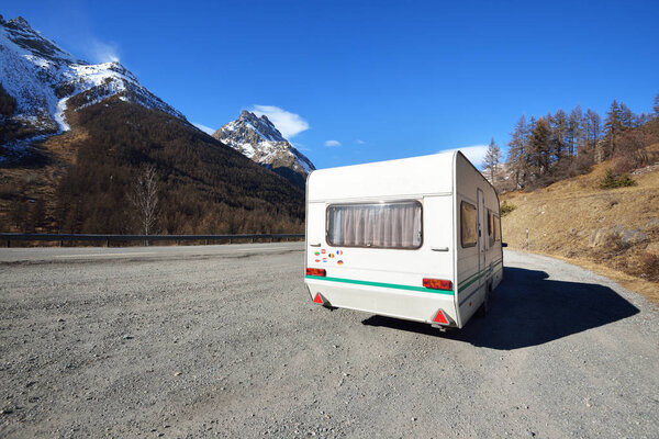 Караван с велосипедом, припаркованным на асфальтированной дороге в горах Фенч Альп. Экринс, Парк
