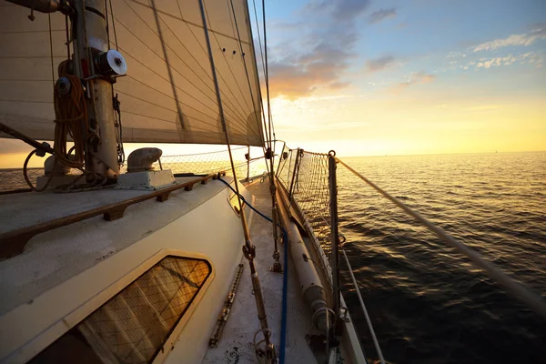 从甲板上俯瞰夕阳西下迎风倾斜的游艇的船头 — 图库照片