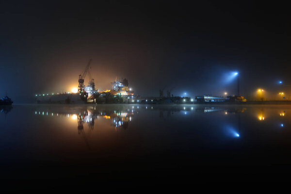 Cargo ships in the port with lights at night