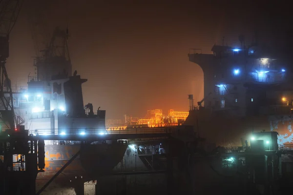 Cargo ships in the port with lights at night