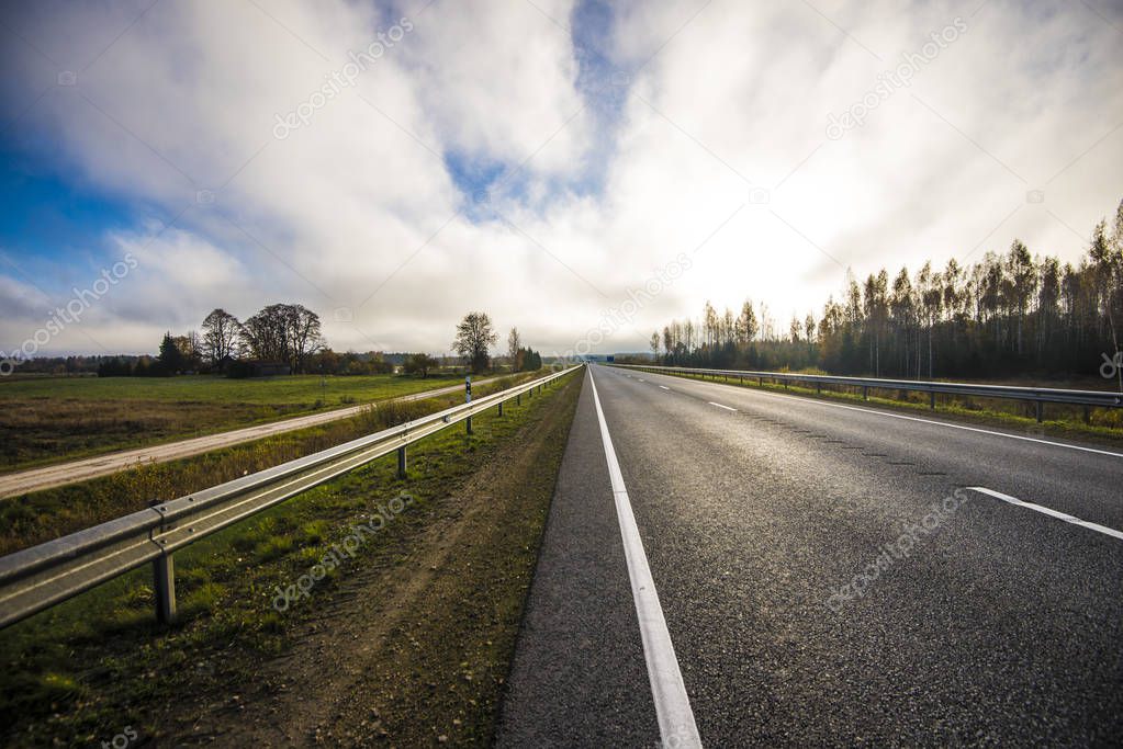 A view of the asphalt country road in Latvia on a clear autumn day