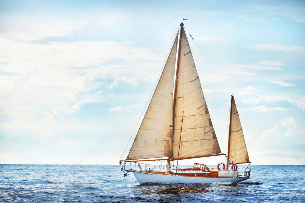 Vintage wooden two mast yacht (yawl) sailing in a open sea on a clear day