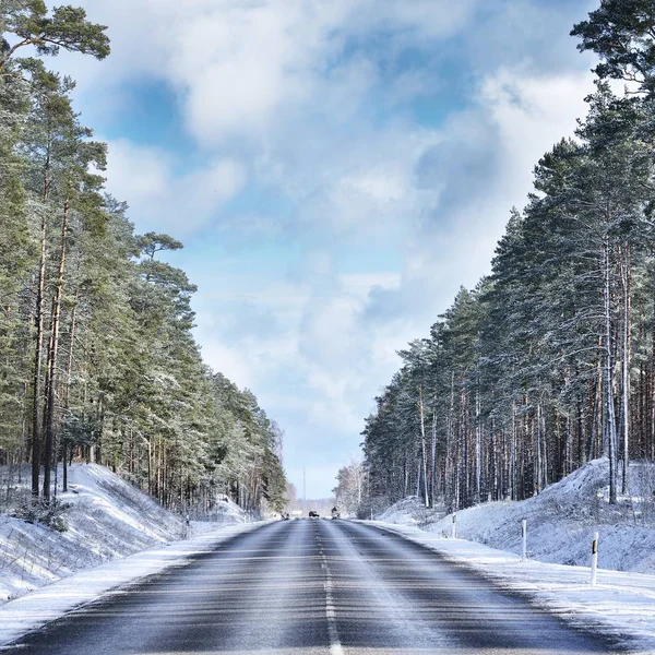 冬季森林中的汽车路对多云的天空 — 图库照片