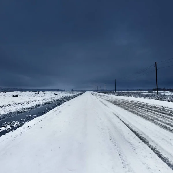 雪下水路付近の未舗装の砂利道 — ストック写真
