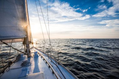 Gün batımında denize açılacağız. Yat güvertesinden pruva ve yelkenlere bir manzara. Baltık Denizi, Letonya