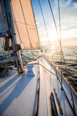 Gün batımında denize açılacağız. Yat güvertesinden pruva ve yelkenlere bir manzara. Baltık Denizi, Letonya