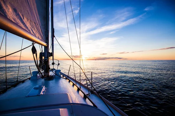 Sailing at sunset. A view from the yacht\'s deck to the bow and sails, Baltic sea, Latvia