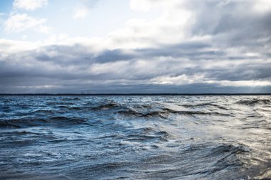 Kış yelkenlisi. Gün batımında soğuk mavi deniz. dalgalar ve bulutlar, Norveç