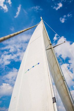 Direğin yakın görüntüsü ve bulutlu mavi gökyüzüne karşı yelkenler. Baltık Denizi, Estonya