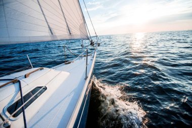 Gün batımında denize açılacağız. Yat güvertesinden pruva ve yelkenlere bir manzara. Baltık Denizi, Letonya