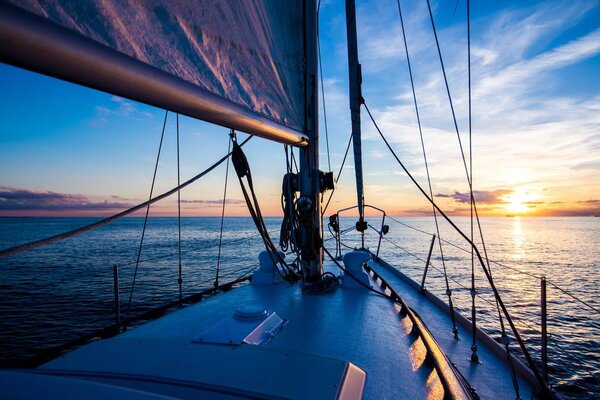 Sailing at sunset. A view from the yacht's deck to the bow and sails, Baltic sea, Latvia