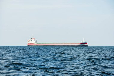 Bulutlu mavi gökyüzünün altında kargo gemisi, Baltık denizi, Letonya