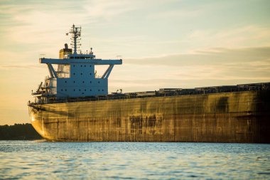 Gün batımında Riga limanında kargo gemisi, Letonya