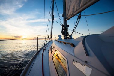 Gün batımında denize açılıyor. Yat güvertesinden yay ve yelkenlere, Baltık denizine, Letonya'ya bir manzara