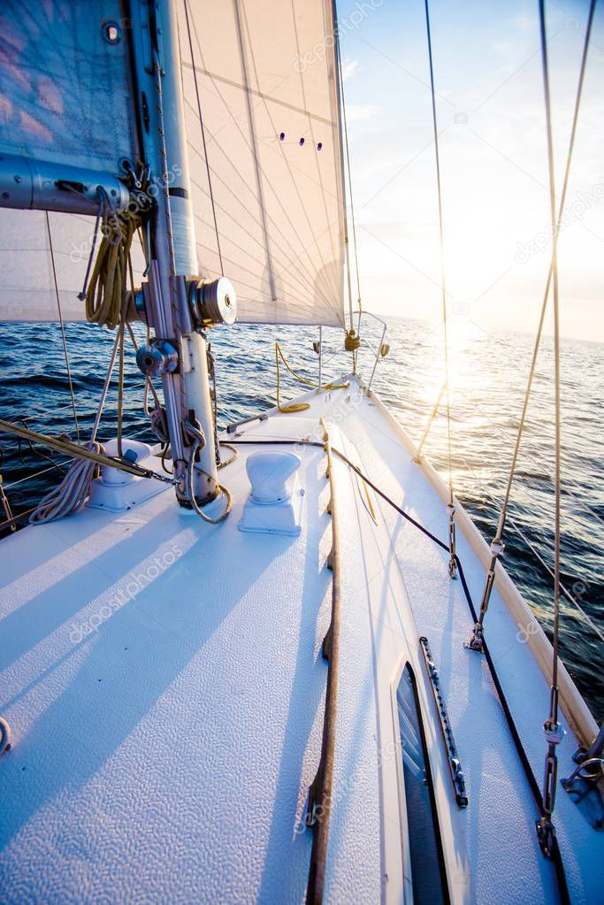 Sailing at sunset. A view from the yacht's deck to the bow and sails. Close-up. Baltic sea, Latvia
