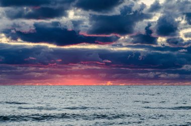 Bulutlarla renkli yaz gün batımı. Baltık Denizi, Letonya