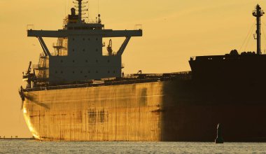 Gün batımında Riga limanında kargo gemisi, Letonya