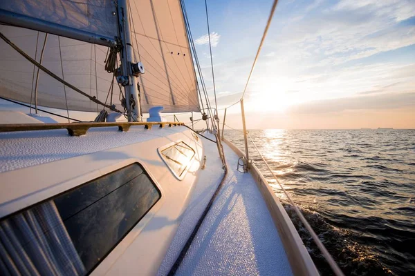 Sailing at sunset. A view from the yacht's deck to the bow and sails. Baltic sea, Latvia