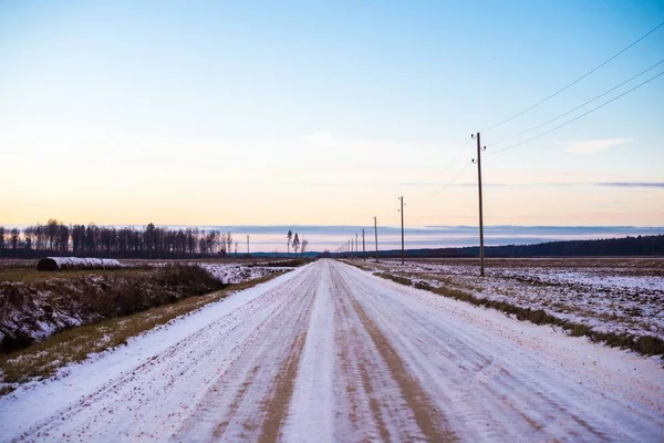 Smuts Snötäckt Landsväg Genom Fälten Vid Solnedgången Skogen Bakgrunden Lettland — Stockfoto