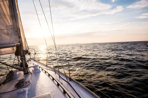 Sailing at sunset. A view from the yacht\'s deck to the bow and sails. Baltic sea, Latvia