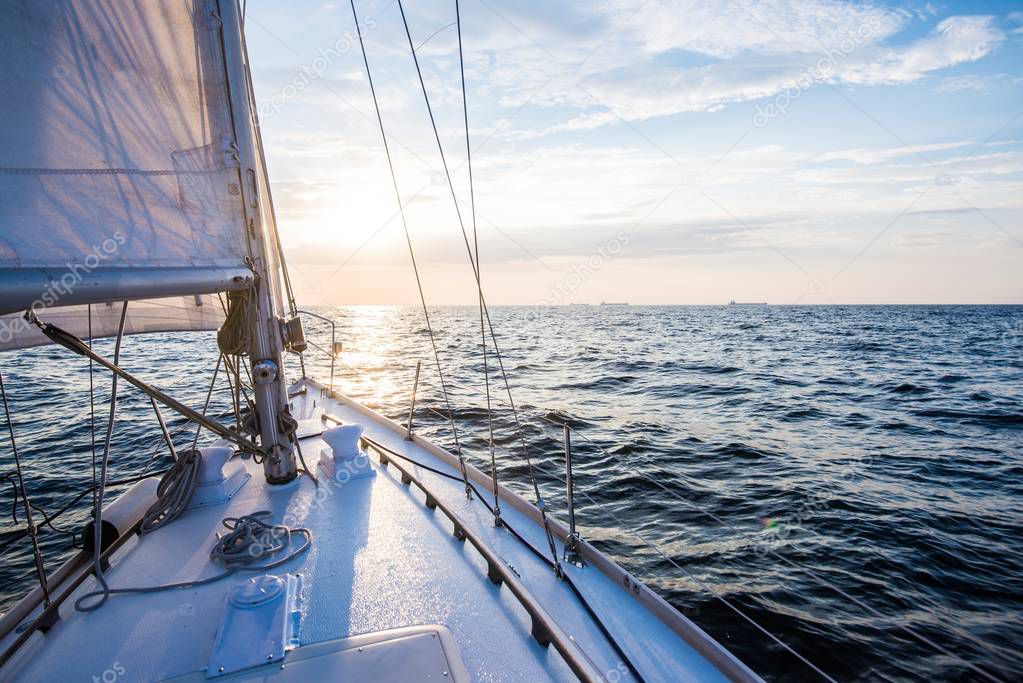 Sailing at sunset. A view from the yacht's deck to the bow and sails. Baltic sea, Latvia