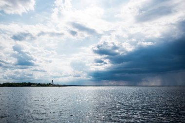Baltık denizi nin manzarası ve fırtınalı gökyüzünün altında bir deniz feneri, Letonya
