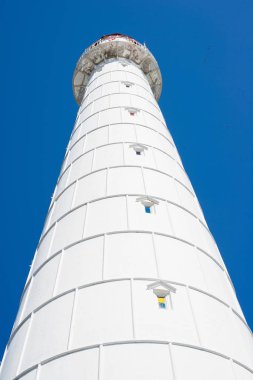 Güneşli bir günde berrak mavi gökyüzüne karşı beyaz deniz feneri. Estonya, Hiumaa Adası