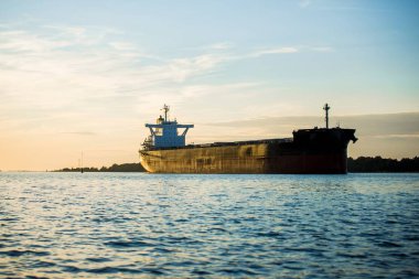 Gün batımında Riga limanında kargo gemisi, Letonya