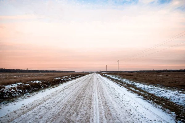 Smuts Snötäckt Landsväg Genom Fälten Vid Solnedgången Skogen Bakgrunden Lettland — Stockfoto