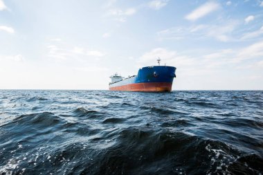 Bulutlu mavi gökyüzünün altında kargo gemisi, Baltık denizi, Letonya