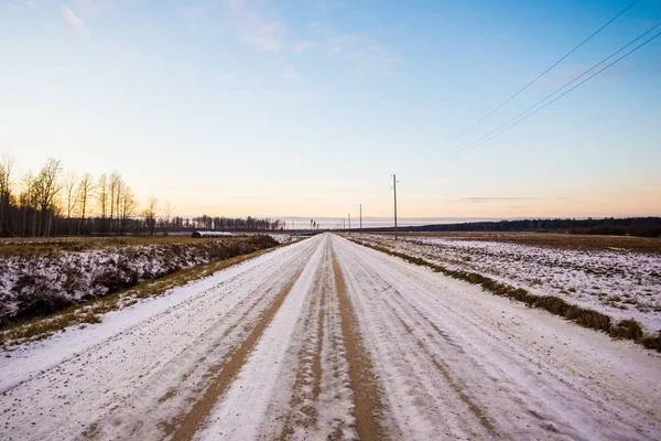 Smuts Snötäckt Landsväg Genom Fälten Vid Solnedgången Skogen Bakgrunden Lettland — Stockfoto