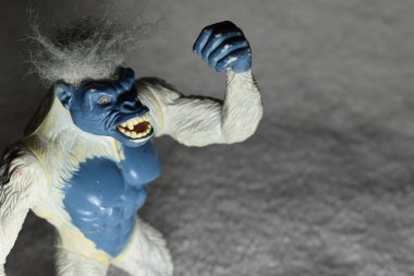 Beyaz ve mavi kızgın goril oyuncak havada yumruk sallayarak.