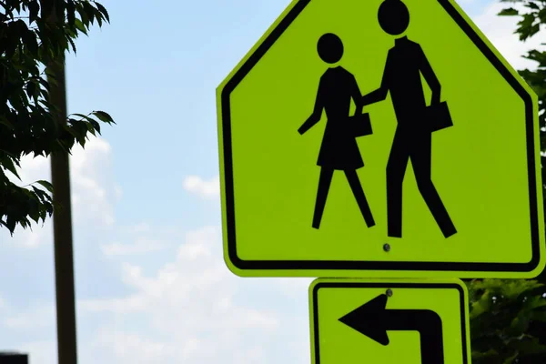 Green-yellow school crossing sign.