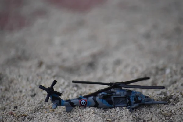 Kids toy attack helicopter airforce on sand closeup view.