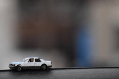 Bulanık arka plan ile siyah platformüzerinde beyaz ve mavi oyuncak yarış arabası.