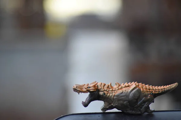 Dinosaurier Rennspielzeug Auf Schwarzer Plattform Mit Verschwommenem Hintergrund — Stockfoto