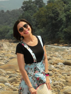 Nehirde gülümseyen Asyalı kadın.